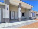 The entryway shows the pillars with wall lighting and a front door with sidelight windows at 2150 S Manzanita Dr, Pahrump, NV 89048
