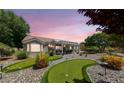 A backyard with a putting green and a covered patio in a landscaped yard with rock groundcover at 2509 Big Timber Dr, Las Vegas, NV 89134
