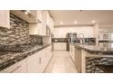 A gourmet kitchen featuring sleek countertops, white cabinetry, and stainless-steel appliances at 2913 Monate Ct, Henderson, NV 89044