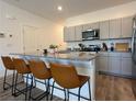 Modern kitchen with stainless steel appliances, gray cabinets, and granite countertops at 4273 Venus Falls Ave, North Las Vegas, NV 89084