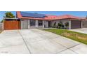 Charming single-story home featuring a red tile roof, solar panels, and a large driveway at 5734 Duval Dr, Las Vegas, NV 89156