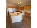 Kitchen features an island, wooden cabinetry, and modern appliances at 6425 Sierra Sands St, North Las Vegas, NV 89086