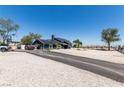 Spacious property with a long driveway leading to a gray home with solar panels at 7135 Polaris Ave, Las Vegas, NV 89118