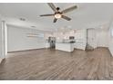 Bright, open-concept living space with wood flooring, a ceiling fan, and an eat-in kitchen with stainless steel appliances at 8011 Cavazzo Ave, Las Vegas, NV 89178