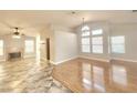 Bright and airy living room with hardwood flooring, neutral walls, large windows, and a fireplace at 8220 Desert Beach Dr, Las Vegas, NV 89128