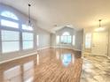 Spacious living room featuring hardwood floors, high ceilings, large windows, and modern lighting fixtures at 8220 Desert Beach Dr, Las Vegas, NV 89128