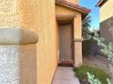 Neutral colored front door, framed by the textured stucco exterior at 9148 Patrick Henry Ave, Las Vegas, NV 89149