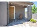 Cozy front porch with brick pillars, pavers and a rocking chair, creating an inviting entrance at 9451 Lunar Ray St, Las Vegas, NV 89143