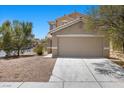 Two story home with a two car garage, neutral stucco exterior, and low maintenance desert landscaping at 9625 Gatesville Ave, Las Vegas, NV 89148