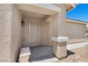 Inviting entryway featuring a security door, front porch bench, and neutral stucco exterior at 9625 Gatesville Ave, Las Vegas, NV 89148