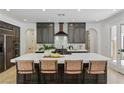 Modern kitchen with an island, white countertop, dark wood cabinets, and stainless steel appliances at 11775 Woodbrook Ct, Las Vegas, NV 89141