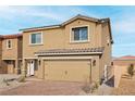 Two-story home showcasing an attached two-car garage and a tiled roof at 1701 Desert Path Ave, North Las Vegas, NV 89032