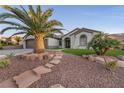 Well-manicured front yard with mature palm trees and stepped stone walkway to the front entrance at 1999 Oliver Springs St, Henderson, NV 89052