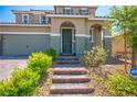 Front exterior of a two-story home featuring brick steps leading to a covered porch and green landscaping at 2577 Tolmezzo St, Henderson, NV 89044