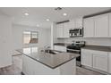 Modern kitchen featuring an island with a sink, stainless steel appliances, and stone countertops at 4253 Gold Desert St, North Las Vegas, NV 89032