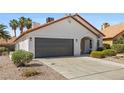 View of the home with a two-car garage, stucco exterior, and desert landscaping at 4324 Peaceful Path Ct, North Las Vegas, NV 89032