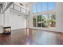 Spacious living room with concrete floors, fireplace, balcony, and large windows with views of the backyard at 5603 Deer Creek Falls Ct, Las Vegas, NV 89118