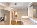 View of the kitchen with stainless steel appliances, granite countertops, and wood-look flooring at 6160 Rumrill St # 215, Las Vegas, NV 89113