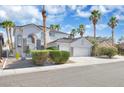 Charming two-story home featuring a two-car garage, desert landscaping, and mature palm trees at 6909 Fruit Flower Ave, Las Vegas, NV 89130