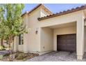 A close-up of a well-maintained home exterior featuring a covered garage and desert landscaping at 7472 Garnet Moon St, North Las Vegas, NV 89084
