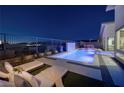 Backyard pool with water feature, surrounded by lounge chairs and landscaped area at nighttime at 794 Willits St, Las Vegas, NV 89138