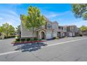 Exterior shot showcasing the townhome's architecture, landscaping, and convenient parking at 9975 Peace Way # 2009, Las Vegas, NV 89147