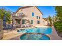 Backyard features a sparkling pool, jacuzzi, covered patio, and a comfortable seating area at 1513 Ravanusa Dr, Henderson, NV 89052