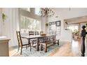 Bright dining room with a rustic wood table, bench seating, chandelier, and large windows providing natural light at 1513 Ravanusa Dr, Henderson, NV 89052