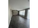 Open living space with dark tile floors, neutral walls, a built in entertainment center, and large windows at 5709 Nobleton Ct, North Las Vegas, NV 89081