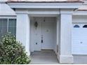 Close-up of the front door with detailed molding, hardware, and a textured white exterior at 577 Leap Frog Ave, Las Vegas, NV 89183