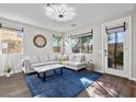Bright and spacious living room with stylish decor, a large sectional sofa, and access to the backyard at 8353 Lower Trailhead Ave, Las Vegas, NV 89113