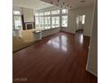 Bright living room features dark wood flooring, a fireplace, and many windows for lots of natural light at 8761 Rainbow Ridge Dr, Las Vegas, NV 89117