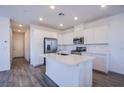 Bright kitchen featuring stainless steel appliances, stylish gray tile flooring, and a functional center island at 145 Aqua Commons Ln, Henderson, NV 89015