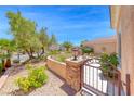 Gated courtyard with stone accents, mature landscaping, and walkway to the front door at 2205 Sandstone Cliffs Dr, Henderson, NV 89044