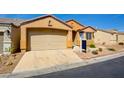 Tan single-story home with desert landscaping, a two-car garage and front entrance at 3429 Glacial Lake St, Las Vegas, NV 89122