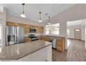 Well-lit kitchen featuring stainless steel appliances, a center island, and wood-style flooring, providing ample counter space at 5001 Morning Falls Ave, Las Vegas, NV 89131