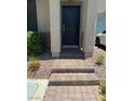 Inviting entryway with a black front door and brick-paved steps at 5414 Enchanted Rose St, Las Vegas, NV 89148
