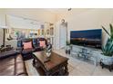 Comfortable living room with a plush leather sofa, modern TV, and tiled flooring, creating an inviting and relaxing space at 5914 Rose Sage St, North Las Vegas, NV 89031