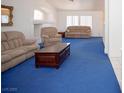 Bright living room with vaulted ceilings, fireplace, and plush blue carpet at 6249 Halehaven Dr, Las Vegas, NV 89110