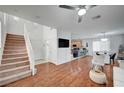 Open-concept living space with stairs, wood floors, and seamless flow to kitchen and dining area at 635 Taliput Palm Pl, Henderson, NV 89011