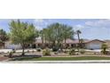 Sprawling single-story home with a well-kept yard featuring lush landscaping and mature trees at 825 W Ryan Ave, Overton, NV 89040