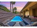 Inviting backyard pool with sun loungers and a covered patio, perfect for relaxing and entertaining guests at 9015 Chopper Prairie St, Las Vegas, NV 89131
