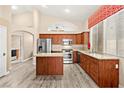 Bright eat-in kitchen with a center island and wood cabinets, complemented by light-colored flooring at 9733 Northern Dancer Dr, Las Vegas, NV 89117