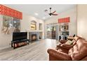 Inviting living room featuring a cozy fireplace, ceiling fan, and sliding glass doors to backyard at 9733 Northern Dancer Dr, Las Vegas, NV 89117