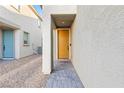 Inviting entryway features a yellow front door and stone pathway at 10347 Restless River St, Las Vegas, NV 89141