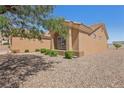 Tan single-story home featuring low maintenance desert landscaping and a window at 10428 Villa Ridge Dr, Las Vegas, NV 89134
