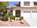 Home featuring manicured landscaping leading up to a covered front entryway at 1700 Double Arrow Pl, Las Vegas, NV 89128
