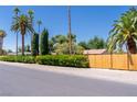 View of residential property showcasing mature landscaping, a wooden fence, and curb appeal at 1911 Valley Dr, Las Vegas, NV 89108