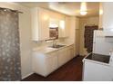 Galley kitchen with white cabinets, laminate countertops and dark floors at 2813 Willoughby Ave, Las Vegas, NV 89101