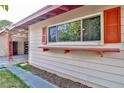 Exterior view featuring a window with red shutters, enhanced by a charming wooden shelf at 304 Perkins Cir, Las Vegas, NV 89106